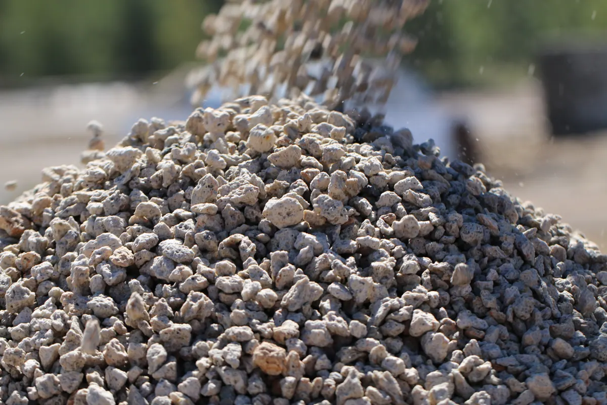 A close view of screened natural pumice falling onto a pile